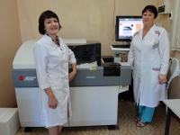 Слева направо:  Заведующая клинико-диагностической лабораторией Гуртовая Г.В.,  врач клинической лабораторной диагностики Боровская Н.А., на фоне биохимического анализатора «AU 480»